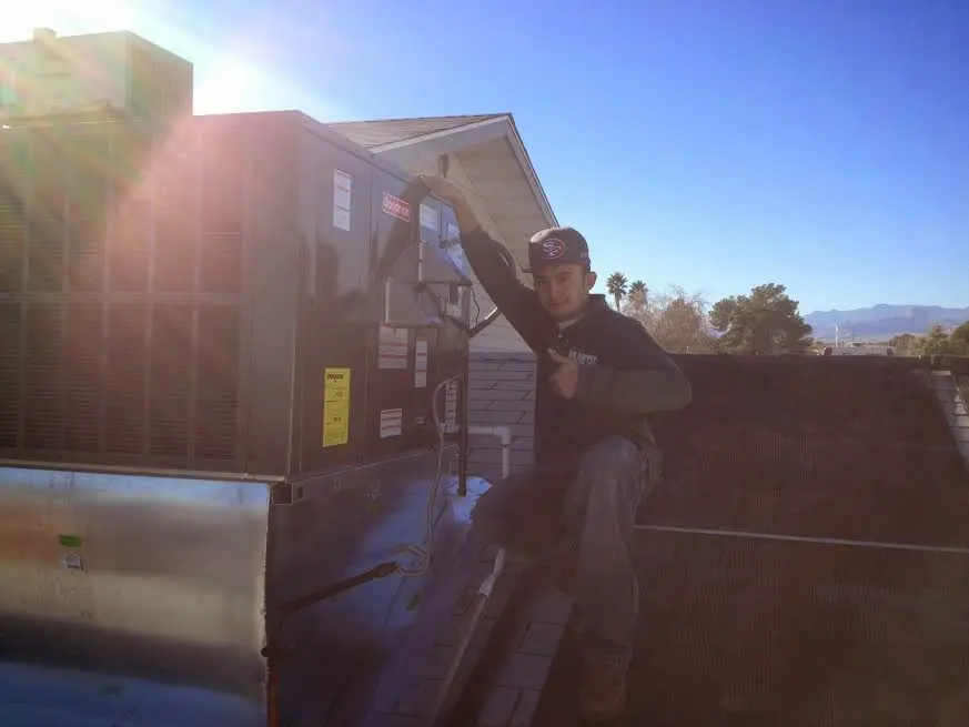HVAC technician performing Air Duct Repair on a rooftop unit in Airway Heights